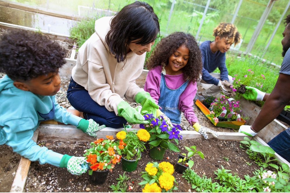 Social worker with school kids woring at garden